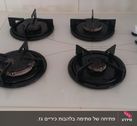 כיריים גז עם ארבעה מבערים וכפתורי שליטה